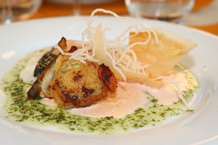Merlu cuit en papillote, écume de fruits de mer à la tomate, bulles de tomates à l'huile d'olives, tempura de légumes, sauce coco, citron vert et épices